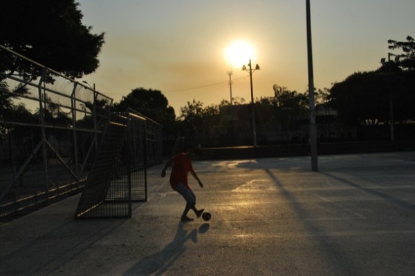Un joven juega con una pelota en el parque Puerto Liza, en Venezuela y la Octava, en el suroeste de Guayaquil.