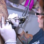 Cindy Parra mientras le hace un tatuaje a Belfort Chávez . tatuadores 11