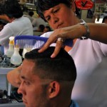 Vicky Anchundia realiza un corte fade a Ronald Franco en la Peluquería Mi Alborada.